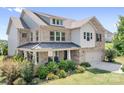 Beautiful two-story brick home featuring a covered porch, manicured landscaping, and an attached garage at 16324 Loch Raven Rd, Huntersville, NC 28078