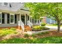 Inviting home exterior with a welcoming front porch, lush landscaping, and a well-manicured lawn at 1887 Steeplechase Dr, Rock Hill, SC 29732