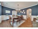 Elegant dining room with dark blue walls, crown molding, and a chandelier at 2205 Gallberry Ln, Waxhaw, NC 28173
