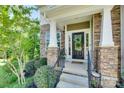 Inviting front entrance with a decorative wreath and stone pillars, creating a welcoming atmosphere at 2205 Gallberry Ln, Waxhaw, NC 28173