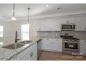 Modern kitchen with white cabinets, granite countertops, stainless steel appliances and eat in island with sink at 2207 Catawba Trace Dr, Catawba, NC 28609
