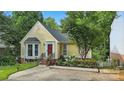 Charming yellow home featuring a red door, bay window, and beautifully landscaped front yard at 2308 Blair House Ct, Charlotte, NC 28270