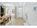 Bright foyer with plank flooring, white door, transom window, and view into the dining area at 265 Miramar Dr, York, SC 29745