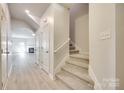 Inviting hallway with staircase leading to the upper level and modern, neutral decor at 5033 Mockernut Ln, Indian Land, SC 29707
