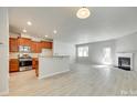 Open-concept living space with fireplace, light wood floors, and ample natural light at 5033 Mockernut Ln, Indian Land, SC 29707