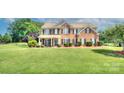Beautiful brick two-story home with lush green lawn and mature landscaping, perfect for Gathering living at 604 Palmerston Ln, Waxhaw, NC 28173