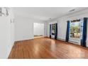 Bright living room featuring hardwood floors, large windows, and neutral walls at 7501 Glencannon Dr, Charlotte, NC 28227