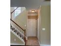 Inviting entryway with staircase, neutral walls, white trim, and tile flooring offering a clean transition at 8125 Weeping Fig Ln, Charlotte, NC 28215