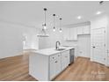 Open-concept kitchen featuring quartz countertops, stainless steel appliances, and modern pendant lighting at 8303 Adrian Ct, Charlotte, NC 28270