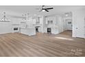 Spacious open-concept kitchen and living area with wood floors, white cabinets, and modern appliances at 8303 Adrian Ct, Charlotte, NC 28270