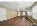 Empty living room with hardwood floors, neutral colored walls, and a white front door at 8604 Rockmoor Ridge Rd, Charlotte, NC 28215