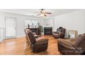 Bright living room featuring hardwood floors, fireplace, and comfortable brown leather seating at 9236 Clifton Meadow Dr, Matthews, NC 28105