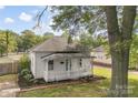 Exterior view of a quaint one-story home with a inviting front porch, and lush greenery at 1008 Valley St, Kannapolis, NC 28081