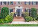 Charming front door with brick steps, elegant landscaping and black shutters at 10127 Tallent Ln, Huntersville, NC 28078