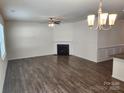 Bright living room with hardwood floors, a cozy fireplace, and a modern ceiling fan at 10410 Bradstreet Commons Way, Charlotte, NC 28215