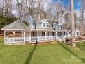 An exterior shot showcasing the home's gazebo, covered porch, and manicured lawn, creating an ideal outdoor living space at 107 Rutledge Rd, Mount Holly, NC 28120