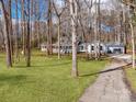 An idyllic shot of the property, framed by trees, showcasing the house and long driveway leading to the attached garage at 107 Rutledge Rd, Mount Holly, NC 28120
