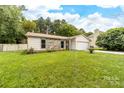 A charming home with stone accents, an attached garage, and a lush green lawn at 10951 Fox Mill Ln, Charlotte, NC 28277