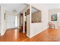 Bright foyer featuring hardwood floors, a decorative mirror, and an open layout at 10951 Fox Mill Ln, Charlotte, NC 28277