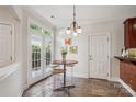 Cozy breakfast nook with tiled floors, round table, three stools, and door to outside at 11234 Villa Trace Pl, Charlotte, NC 28277