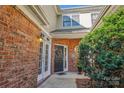 Welcoming entrance with brick exterior, a black door with decorative wreath, and beautiful sidelights at 11234 Villa Trace Pl, Charlotte, NC 28277