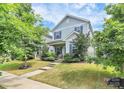 Charming two-story home with blue shutters and a well-manicured front lawn and lush greenery at 11733 Mesquite Rd, Huntersville, NC 28078