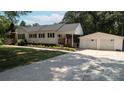 Traditional-style home with detached two-car garage, complemented by a concrete driveway and lush greenery at 1327 Mount Ulla Hwy, Mooresville, NC 28115