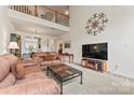 Open living room featuring high ceilings, a loft space, and comfortable leather furniture at 1418 Skidaway Nw St # 427, Concord, NC 28027