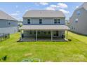 Back of house featuring a covered patio with a brick base, and a view of the spacious backyard at 14505 Rhodes Hall Dr, Charlotte, NC 28273