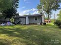A spacious, grassy backyard with trees, featuring playsets, and mature trees at 212 E Texas Ave, Bessemer City, NC 28016