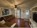 Comfortable living room features hardwood floors, brown sectional sofa, and lots of natural light at 212 E Texas Ave, Bessemer City, NC 28016