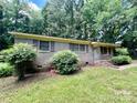Classic brick home with shutters, a small porch, and landscaping in a green yard at 2201 Airdale Rd, Lancaster, SC 29720