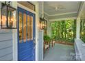 Close-up of a welcoming front porch with stylish lighting and comfortable seating at 2223 Club Rd, Charlotte, NC 28205