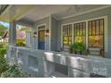 Inviting front porch with stylish seating, decor, and a view of the surrounding landscape at 2223 Club Rd, Charlotte, NC 28205