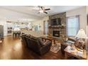 Inviting living room with stone fireplace, hardwood floors, and open kitchen view at 274 Cove Creek Loop, Mooresville, NC 28117