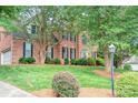 Beautiful brick home features lush landscaping, a side-entry garage, and a well-maintained lawn at 3112 Planters Ridge Rd, Charlotte, NC 28270