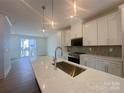 Bright kitchen featuring a quartz island with sink, pendant lighting, and stainless steel appliances at 3618 S Tryon St # 19, Charlotte, NC 28217