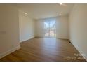 Spacious living room with wood floors and sliding glass door to balcony, offering natural light at 3618 S Tryon St # 19, Charlotte, NC 28217
