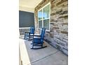 A front porch with two chairs set against a stone facade, perfect for relaxing outdoors at 3816 Rosewood Dr, Mount Holly, NC 28120