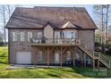 Spacious backyard view showcasing a wooden deck, brick exterior, and outdoor access at 394 Stonecliff Ln, Clover, SC 29710