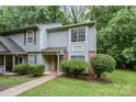 Townhome with green door, brick accents, large windows, and lush landscaping, offering curb appeal at 3941 Briarhill Dr, Charlotte, NC 28215