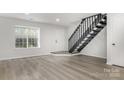 Bright, updated living room with neutral walls, modern flooring, and staircase leading to upper level at 3941 Briarhill Dr, Charlotte, NC 28215