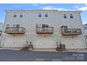 Townhouse rear view featuring private decks above individual garage spaces at 4008 Yucca Aly, Charlotte, NC 28217