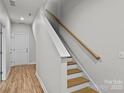 Bright stairway featuring wood treads, white risers, and a natural wood handrail at 4008 Yucca Aly, Charlotte, NC 28217