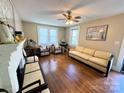 Bright living room with hardwood floors, a fireplace, and a ceiling fan at 450 1St Se St, Hickory, NC 28602