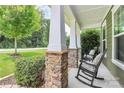 Inviting front porch with stone accents and comfortable rocking chairs offers a relaxing outdoor space at 7011 Hyde Park Dr, Indian Trail, NC 28079