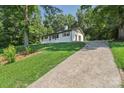 Quaint home with a long driveway lined with lush trees and greenery, ensuring privacy and a serene setting at 848 Ike Lynch Rd, Dallas, NC 28034