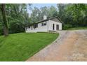Well-maintained white home features a long driveway and lush greenery at 848 Ike Lynch Rd, Dallas, NC 28034