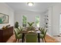 Bright dining room featuring a wooden table with seating for eight and a built-in bookshelf at 9904 Brigstock Ct, Charlotte, NC 28269