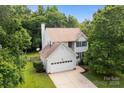 Well-maintained two-story house with an attached garage and a lush green lawn at 9904 Brigstock Ct, Charlotte, NC 28269